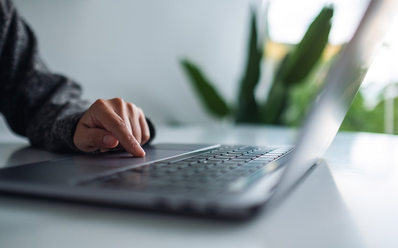 Person scrollt auf einem Laptop mit flackerndem Bildschirm